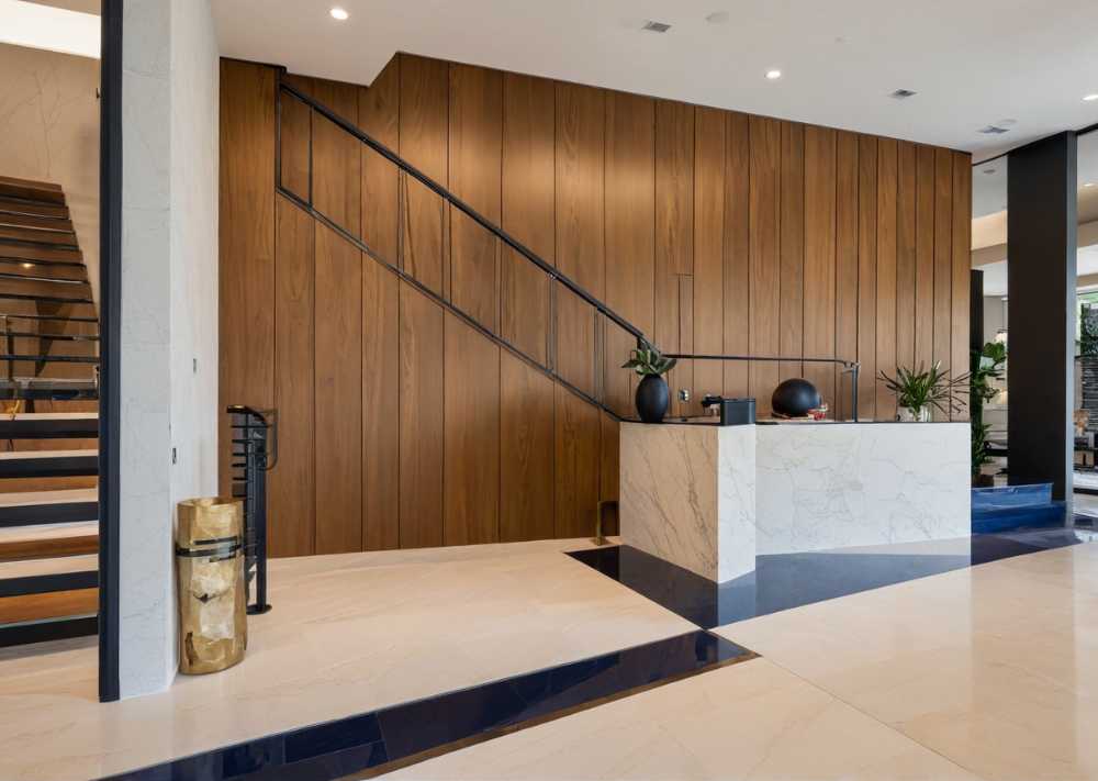 A stylish entrance with a wooden wall and elegant marble flooring, setting a warm and sophisticated tone.